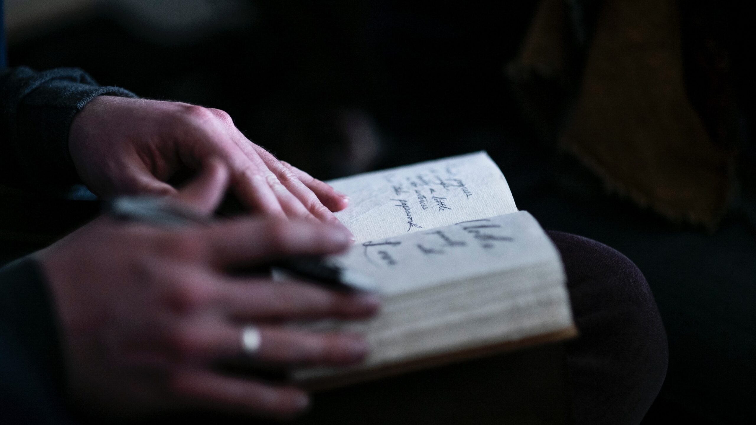 woman's hands flipping through hand written journal